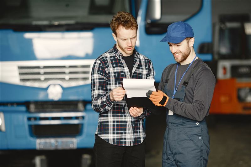 Checking maintenance paperwork in a truck garage