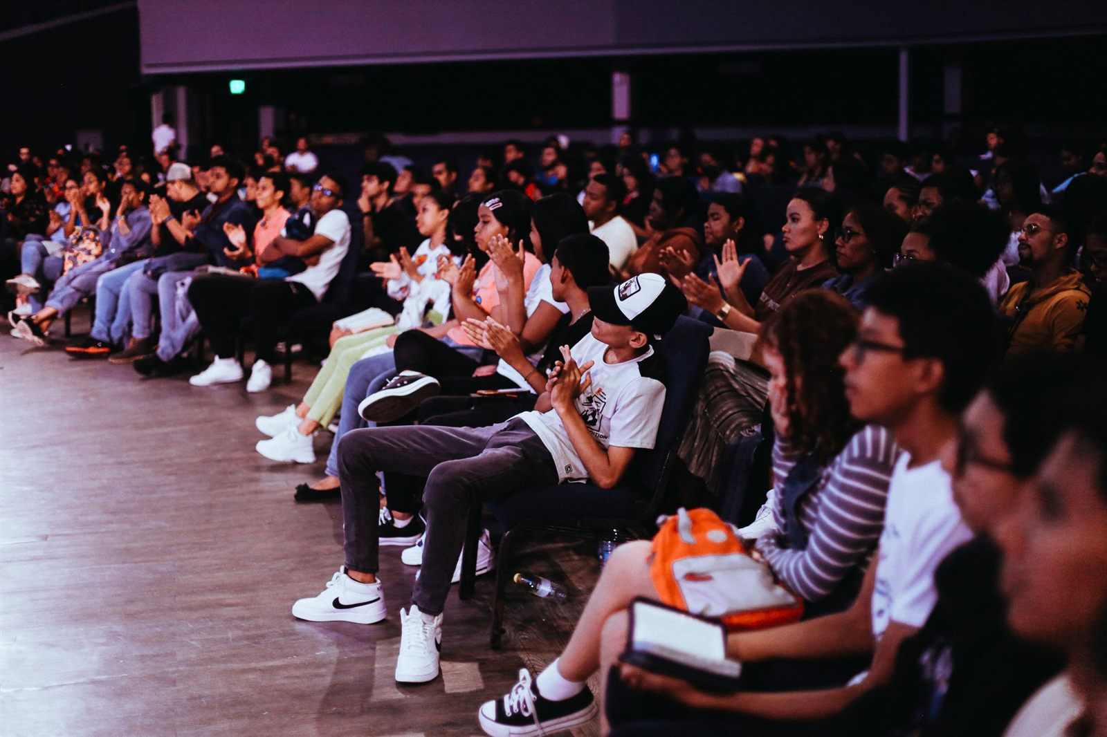 Seated audience applauding at an indoor event
